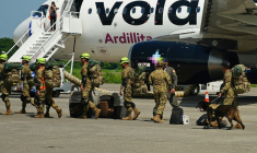 Des militaires salvadoriens accompagnés de chiens renifleurs se préparent à embarquer à bord d’un avion à destination du Venezuela, sur la base aérienne de Comalapa à San Luis Talpa, au Salvador, le 25 juin 2026 ( AFP / Rudy QUIROZ )