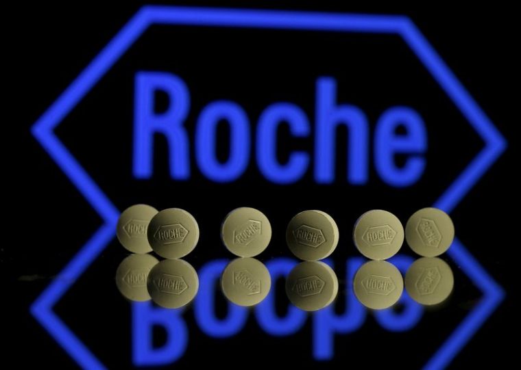 Des comprimés Roche sont disposés devant un logo Roche dans cette illustration