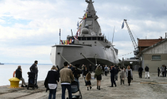 Des promeneurs aux abords de la frégate Kimon de la marine grecque, amarrée au port de Thessalonique, avant les célébrations marquant la fête nationale du "Non", le 25 octobre 2026 en Grèce ( AFP / Sakis Mitrolidis )