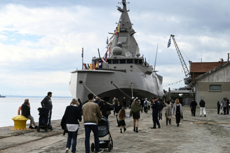 Des promeneurs aux abords de la frégate Kimon de la marine grecque, amarrée au port de Thessalonique, avant les célébrations marquant la fête nationale du "Non", le 25 octobre 2026 en Grèce ( AFP / Sakis Mitrolidis )