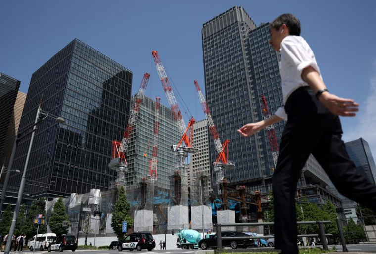 Un homme passe dans la rue près d'un chantier à Tokyo