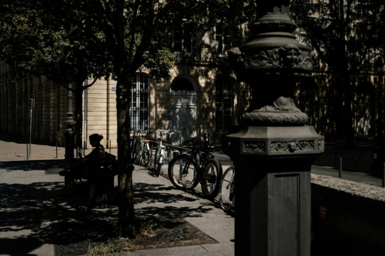 Une femme assise sur un banc à l'ombre à Bordeaux, le 6 juillet 2026 lors d'une vague de chaleur en France ( AFP / Philippe LOPEZ )