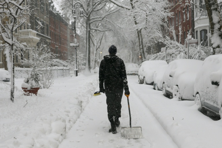 Une passant muni d'un pelle dans le quartier de Brooklyn, lors d'une tempête de neige à New York, le 23 février 2026 ( AFP / ANGELA WEISS )