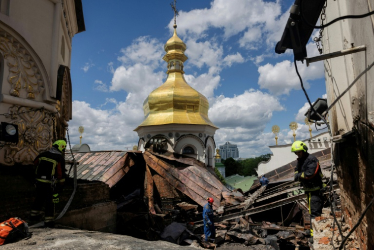 Des pompiers sur le site de la cathédrale orthodoxe de la Dormition, à Kiev, endommagée par un incendie à la suite de frappes de drones et missiles russes sur la capitale ukrainienne, le 15 juin 2026 ( AFP / Tetiana DZHAFAROVA )