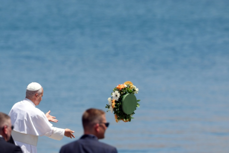 Le pape Léon XIV lance un bouquet de fleurs en mer en hommage aux milliers de migrants morts dans la périlleuse traversée de l'Atlantique depuis l'Afrique, à Arguineguin, aux Canaries, le 11 juin 2026 ( AFP / Pierre-Philippe MARCOU )