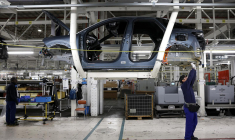 Des employés travaillent sur la chaîne de production de la nouvelle voiture électrique Peugeot e-3008 et e-5008 à l'usine Stellantis de Sochaux, le 3 octobre 2024. ( AFP / FREDERICK FLORIN )