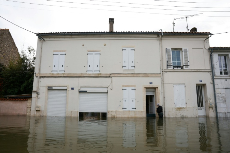 Un habitant pénètre dans une habitation inondée par les crues, le 18 février 2026 à Saintes, en Charente-Maritime ( AFP / ROMAIN PERROCHEAU )