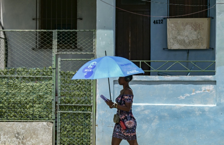 Une femme passe devant une maison en vente à La Havane, le 23 avril 2026 ( AFP / YAMIL LAGE )