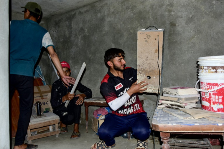 Des habitants nettoient et préparent un bunker souterrain dans le village de Chakothi, au Cachemire sous administration pakistanaise, près de la ligne de contrôle (LoC), le 27 avril 2025 ( AFP / Sajjad QAYYUM )