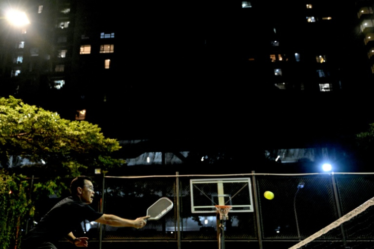 Un homme lors d'une partie nocturne de pickleball à Hanoï, le 23 décembre 2025 ( AFP / Nhac NGUYEN )