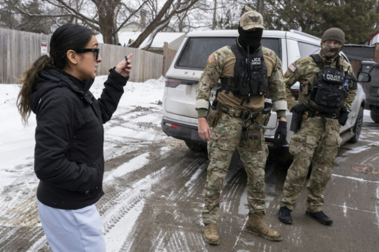 Une femme interpelle des agents de la police de l'immigration à Minneapolis, le 21 janvier 2026 ( AFP / ROBERTO SCHMIDT )