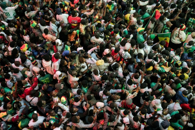 Une foule de supporters de l'équipe de football sénégalaise participent le 20 janvier 2026 à la grande parade populaire à travers Dakar pour célébrer la victoire des Lions de la Teranga en finale de la CAN-2025 face au Maroc  ( AFP / Carmen Abd Ali )