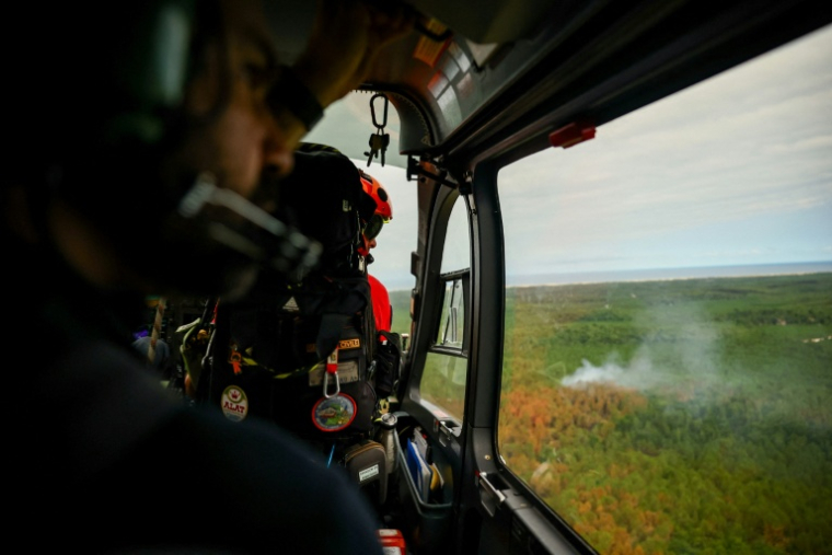Un hélicoptère de la Sécurité en reconnaissance au-dessus d'un incendie de forêt sur la commune de Le Porge, en Gironde, le 31 juillet 2026 ( POOL / Sarah Meyssonnier )