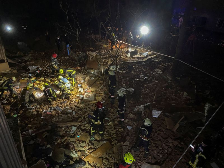 Des pompiers ukrainiens travaillent sur le site d'un immeuble d'habitation gravement endommagé par un tir de missile russe à Kharkov