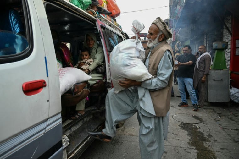 Un habitant charge des sacs de farine dans une camionnette au marché de Muzaffarabad, le 2 mai 2025 au Cachemire pakistanais ( AFP / Farooq Naeem )
