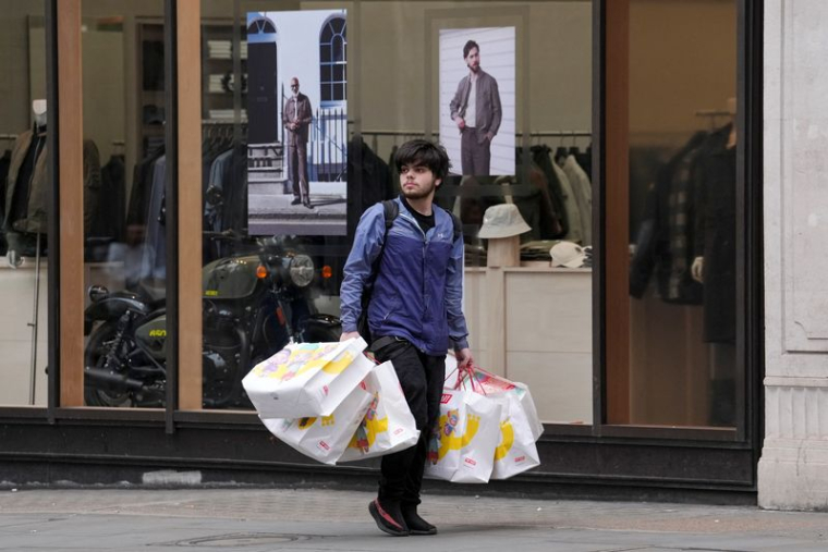Un client portant des sacs Pop Mart marche dans Regent Street, à Londres