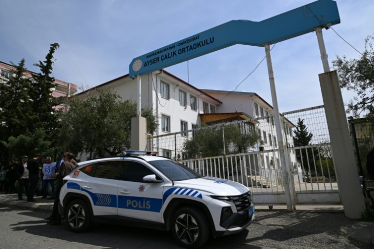 Un véhicule de police stationné devant une école, avant les funérailles des neuf victimes tuées lors d'une fusillade dans un établissement scolaire, le 16 avril 2026 à Kahramanmaraş, dans le sud de la Turquie  ( AFP / YASIN AKGUL )