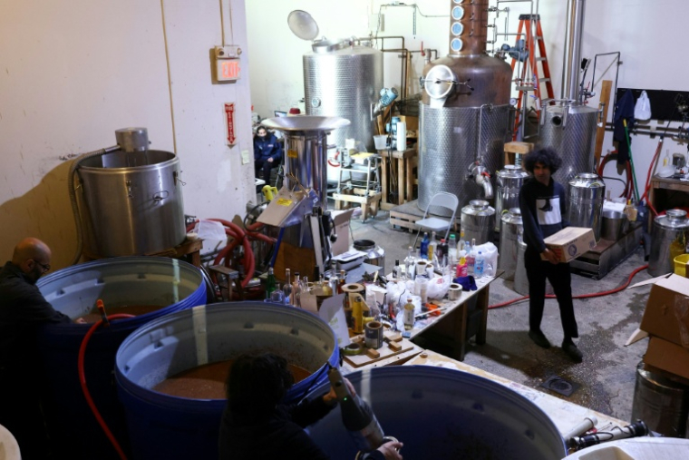 Siavash Karampour (à droite) et Sasan Oskouei (en bas) fabriquent une eau-de-vie traditionnelle iranienne appelée aragh sagi, dans une distillerie de Yonkers, dans l'État de New York, le 21 avril 2026 ( AFP / CHARLY TRIBALLEAU )
