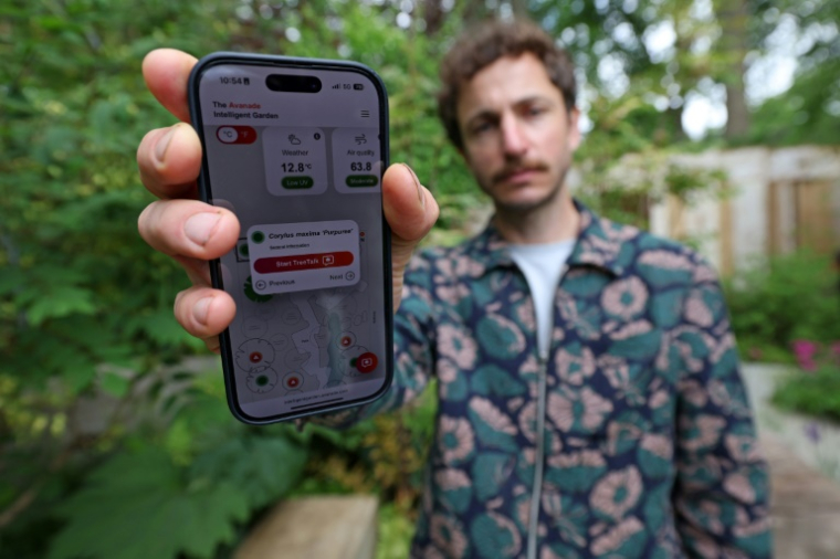 Le paysagiste Tom Massey présente son application qui permet de surveiller la santé des arbres dans son jardin intelligent au Chelsea Flower Show de Londres le 19 mai 2025 ( AFP / Adrian Dennis )
