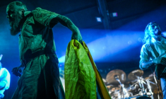 Le meneur du groupe de metal "1914", Dmytro Ternouchtchak (nom de scène "Dmytro Koumar") tient un drapeau ukrainien lors d'un concert à Varsovie, le 25 mars 2026 ( AFP / Sergei GAPON )