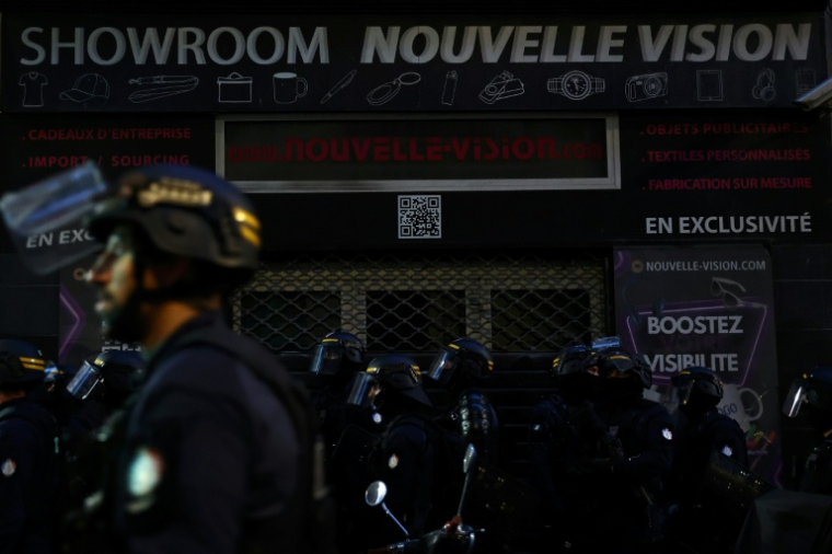 Des policiers antiémeutes devant un magasin équipé d'un rideau de fer lors d'une manifestation, le 24 octobre 2026 à Marseille ( AFP / Thibaud MORITZ )
