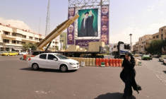 Une femme marche à côté d'un missile désactivé et devant un portrait géant du guide suprême iranien, l'ayatollah Ali Khamenei, à Téhéran le 27 septembre 2025. ( AFP / ATTA KENARE )