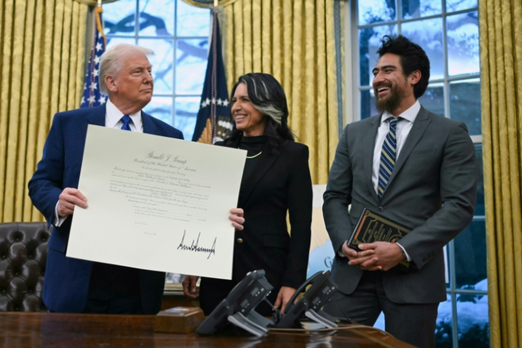 Le président américain Donald Trump, Tulsi Gabbard (c) et son mari Abraham Williams (d) lors de sa nomination officiellement comme directrice nationale du renseignement dans le Bureau ovale de la Maison Blanche, le 12 février 2025 à Washington ( AFP / ANDREW CABALLERO-REYNOLDS )