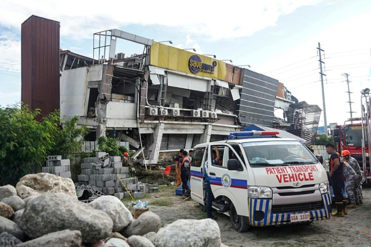 Une ambulance devant un bâtiment effondré après un séisme de magnitude 7,8 à General Santos, le 8 juin 2026 aux Philippines ( AFP / Ferdinandh Cabrera )