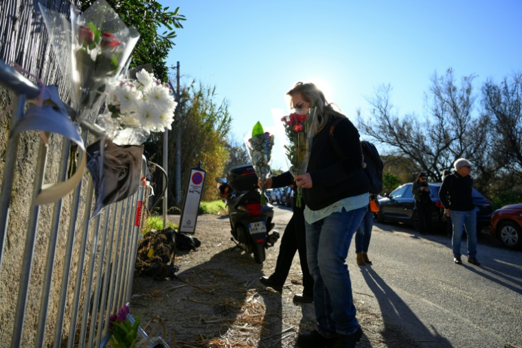 Une femme dépose des fleurs en hommage à Brigitte Bardot à l'entrée de sa propriété de Saint-Tropez, le 28 décembre 2025 ( AFP / Frederic DIDES )