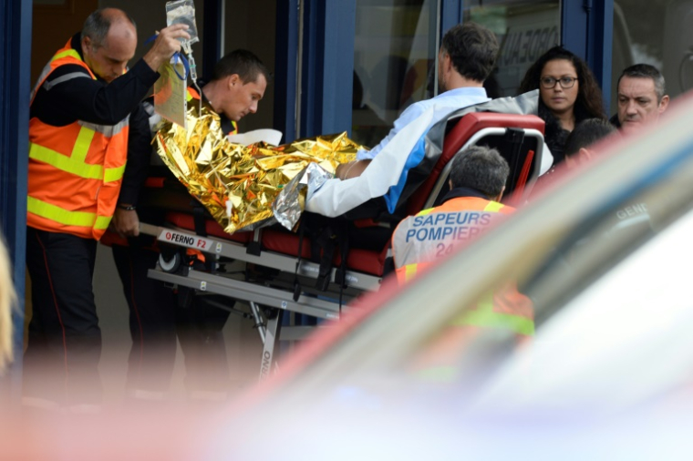 Un pompier évacue un blessé dans l'accident de Puisseguin, le 23 octobre 2015 ( AFP / JEAN-PIERRE MULLER )