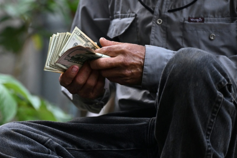 Un vendeur de bétail compte son argent après avoir conclu une vente au Marché municipal du bétail de Sensuntepeque, dans le département de Cabañas, au Salvador, le 1er octobre 2026 ( AFP / Marvin RECINOS )