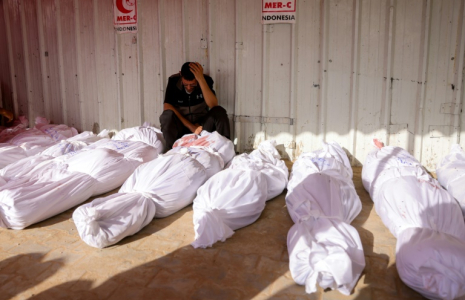 Une homme se recueille devant les corps de victimes de raids israéliens, à l'hôpital indonésien de Jabalia, dans le nord de la bande de Gaza, le 14 mai 2025 ( AFP / BASHAR TALEB )