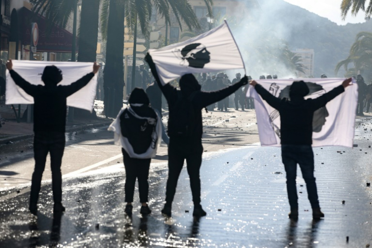Des manifestants brandissent des drapeaux de la Corse face aux CRS, le 3 avril 2022 à Ajaccio, après un rassemblement en hommage au militant indépendantiste Yvan Colonna, mortellement agressé en prison ( AFP / Pascal POCHARD-CASABIANCA )