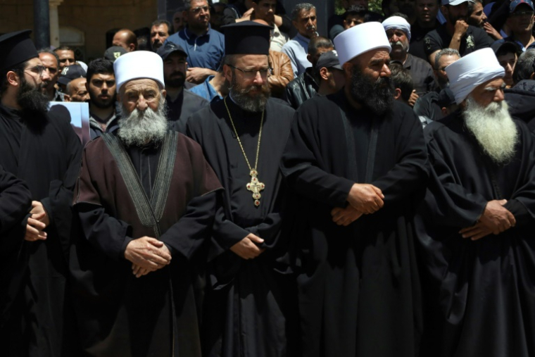Des religieux chrétiens et musulmans assistent à Salkhad dans le sud de la Syrie, aux funérailles de membres de la communauté druze tués lors de combats confessionnels près de Damas, le 3 mai 2025 ( AFP / Shadi AL-DUBAISI )