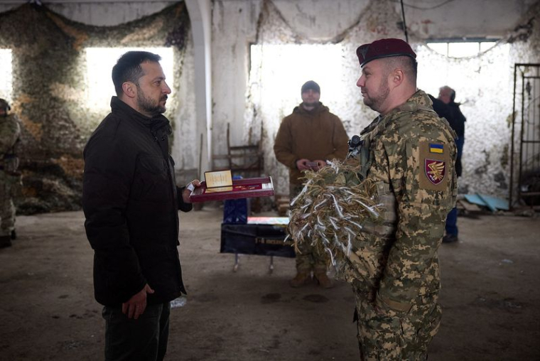Le président ukrainien Volodymyr Zelenskiy récompense un soldat ukrainien alors qu'il visite une position près de la ligne de front près de Koupiansk