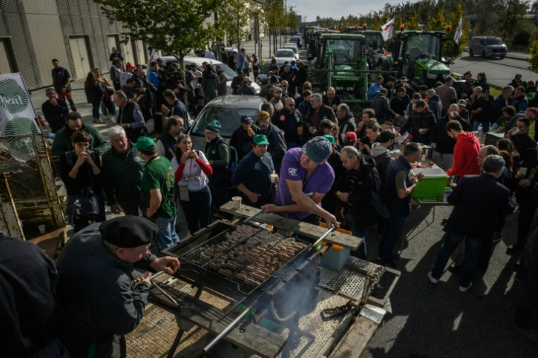 Des agriculteurs préparent un barbecue à Montaudran, près de Toulouse, le 12 novembre 2025, tandis que des membres de la FNSEA et de la Confédération paysanne manifestent contre la visite du président Emmanuel Macron et ses propos sur l'accord commercial du Mercosur ( AFP / Ed JONES )