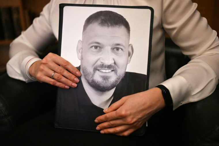 La figure de l'opposition bélarusse en exil, Svetlana Tikhanovskaïa, brandit une photo de son mari emprisonné, le 9 janvier 2025, à Varsovie ( AFP / Sergei GAPON )