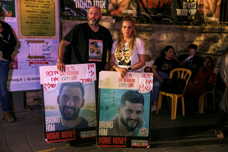 Portraits de Gali et Ziv Berman portés pendant une manifestation de proches d'otages israéliens, à Jérusalem le 4 octobre 2025 ( AFP / AHMAD GHARABLI )