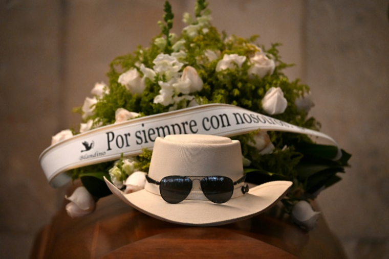 Un chapeau et des lunettes de soleil placés sur le cercueil du chanteur de merengue Rubby Perez, mort dans l'effondrement du toit d'une discothèque où il se produisait, lors de la veillée funèbre organisée au Théâtre national de Saint-Domingue, le 10 avril 2025 ( AFP / Martin BERNETTI )