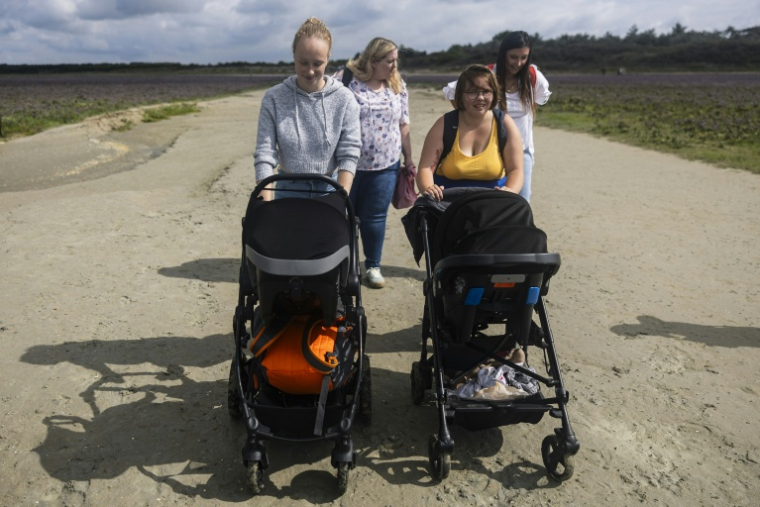 Anne-Marie (à droite), 16 ans, mère d'un bébé de 6 mois, se promène avec Lou-Anne, 17 ans, et son bébé de 11 mois, dans la réserve naturelle de la baie de Somme, le 30 juillet 2025 ( AFP / Sameer Al-DOUMY )