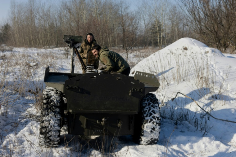 Un militaire ukrainien de la 5e brigade d'assaut indépendante charge des chenilles pour drones sur un véhicule terrestre sans pilote lors d'un entraînement dans un lieu tenu secret de la région de Dnipropetrovsk, le 21 janvier 2026 ( AFP / Tetiana DZHAFAROVA )
