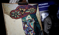 Un employé de l'Hôtel Drouot dévoile le tableau de Pablo Picasso "Buste de femme au chapeau à fleurs" représentant Dora Maar, le 18 septembre 2025 à l'Hôtel Drouot à Paris, avant la mise aux enchères de l'oeuvre le 24 octobre 2025 ( AFP / STEPHANE DE SAKUTIN )