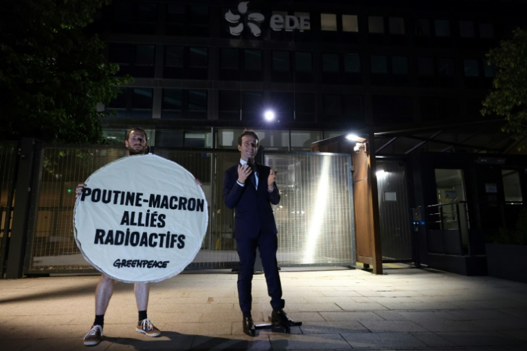 Un militant de l'ONG Greenpeace pose à côté de la statue en cire d'Emmanuel Macron le 3 juin 2025 devant le siège d'EDF à Paris ( AFP / Xavier GALIANA )