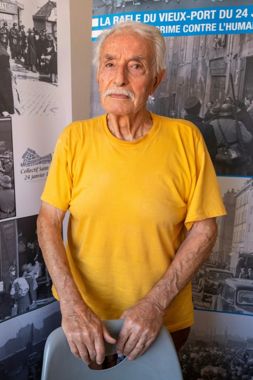 Un survivant des rafles du Vieux-Port de Marseille, Antoine Mignemi, 89 ans, pose devant des photos d'époque à Marseille, le 28 septembre 2026 ( AFP / Miguel MEDINA )