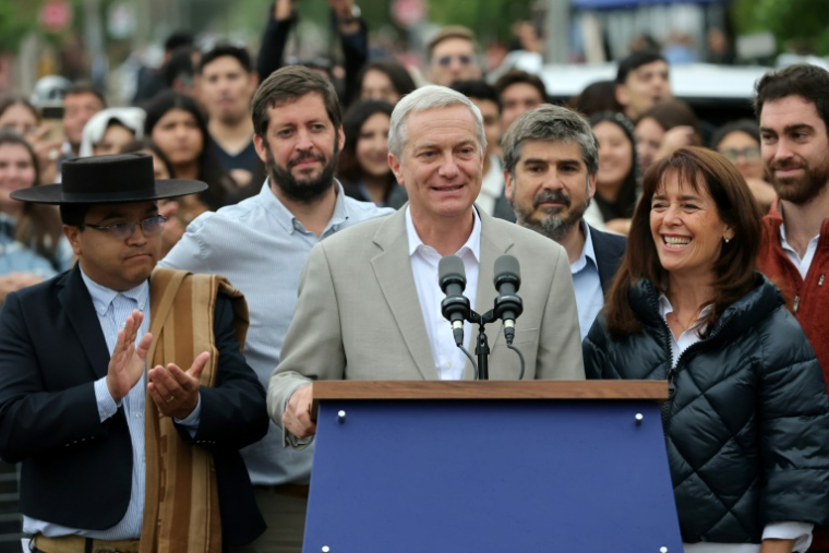 Le candidat à la présidence du Chili, José Antonio Kast, du Parti républicain, parle aux côtés de son épouse Maria Pia Adriasola devant un bureau de vote à Paine, au sud de Santiago, le 14 décembre 2025 ( AFP / Javier TORRES )