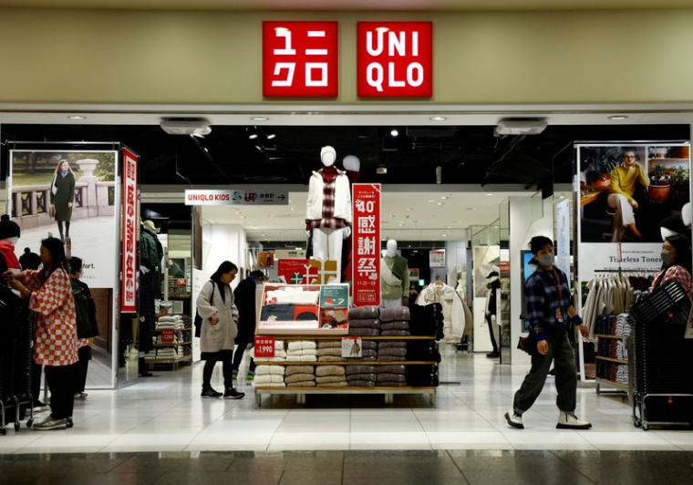 Des clients regardent les vêtements dans un magasin Uniqlo, de la chaîne Fast Retailing, à Tokyo