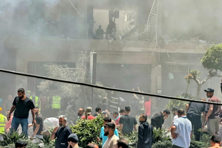 Des habitants recherchent des survivants sur le site d'une frappe aérienne israélienne qui a ciblé un bâtiment dans la banlieue sud de Beyrouth, le 14 juin 2026 au Liban ( AFP / Ibrahim AMRO )