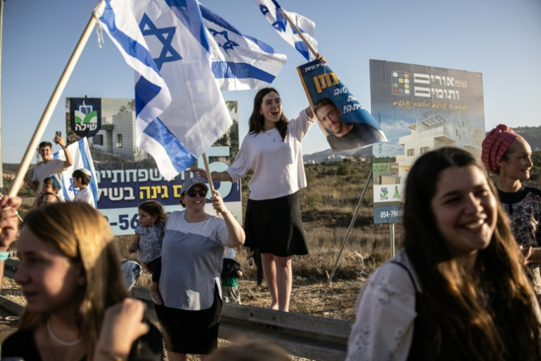 Des Israéliens acclament l'ex-otage à Gaza, Avinatan Or, dans la colonie Shiloh de Cisjordanie, le 21 octobre 2025. ( AFP / John Wessels )