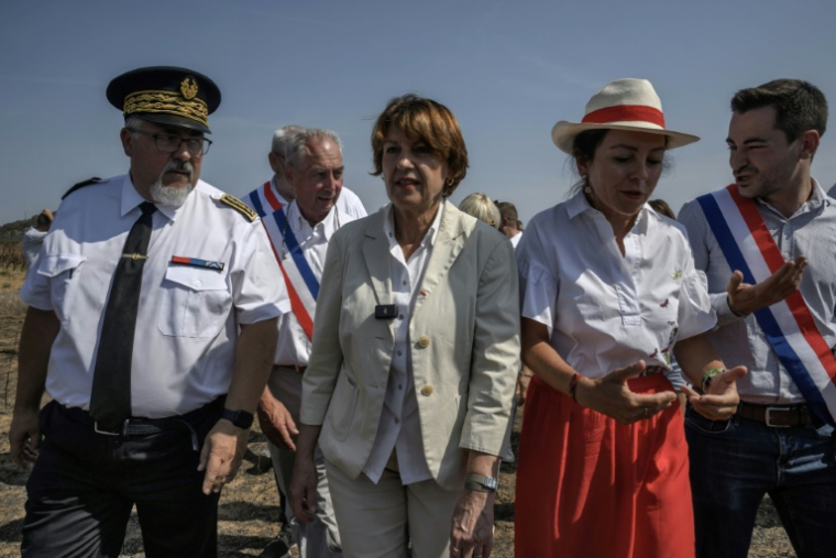 La ministre de l'Agriculture Annie Genevard (C) en visite le 14 août 2025 dans le village viticole de Saint-Laurent-de-la-Cabrerisse (Aude) touché une semaine auparavant par un incendie dévastateur ( AFP / Ed JONES )