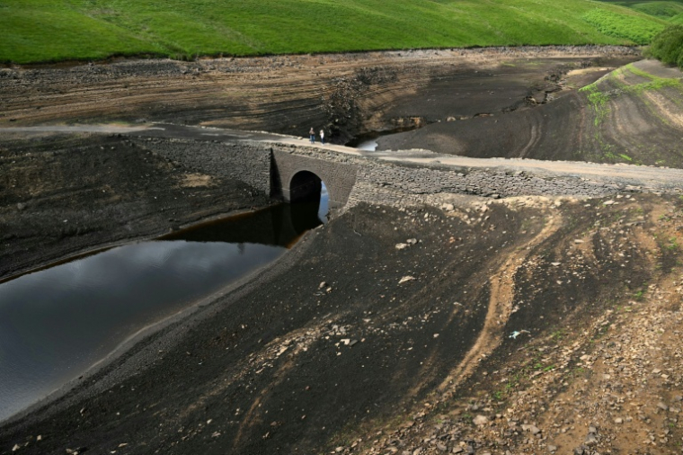 Un pont immergé apparu après la baisse du niveau de l'eau du réservoir de Baitings, près de Ripponden, dans le nord de l'Angleterre, le 16 juillet 2025 ( AFP / Oli SCARFF )